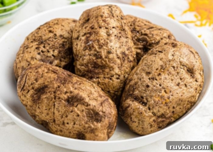 Crispy Air Fryer Loaded Potatoes 6 A white bowl of potatoes after being cooked in the air fryer.