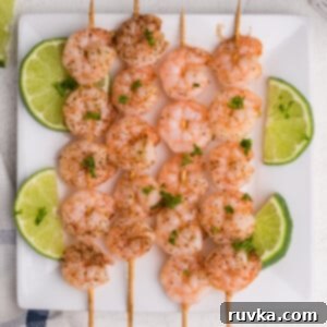 Easy Crispy Air Fryer Shrimp 3 Air Fryer Shrimp Skewers: perfectly grilled shrimp with sliced limes, ideal for appetizers or light meals.