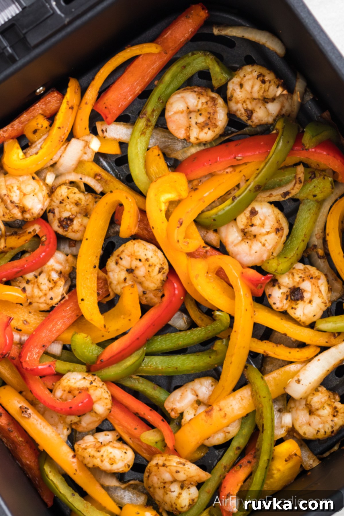 Effortless Air Fryer Shrimp Fajitas 2 Shrimp, bell peppers, and onions, air fried for shrimp fajitas and in the air fryer basket.