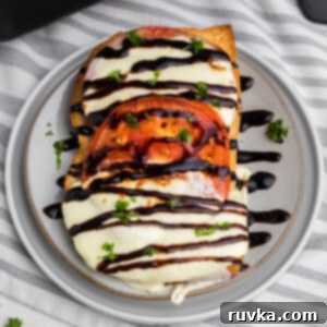 Air Fryer Caprese Melts 10 Caprese grilled cheese sandwich made in the air fryer and served on a plate with balsamic glaze.
