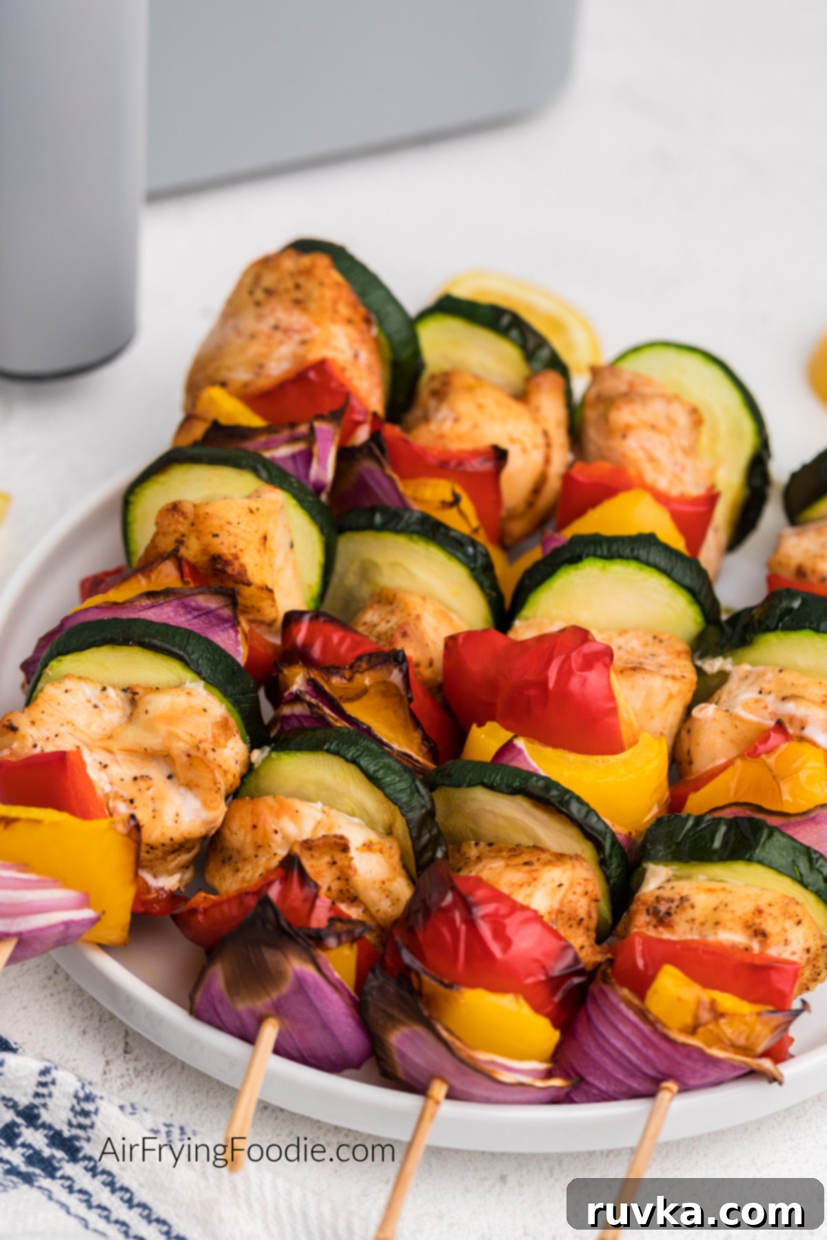 Easy Air Fryer Chicken Kabobs 7 air fried chicken kabobs on a plate ready to serve.