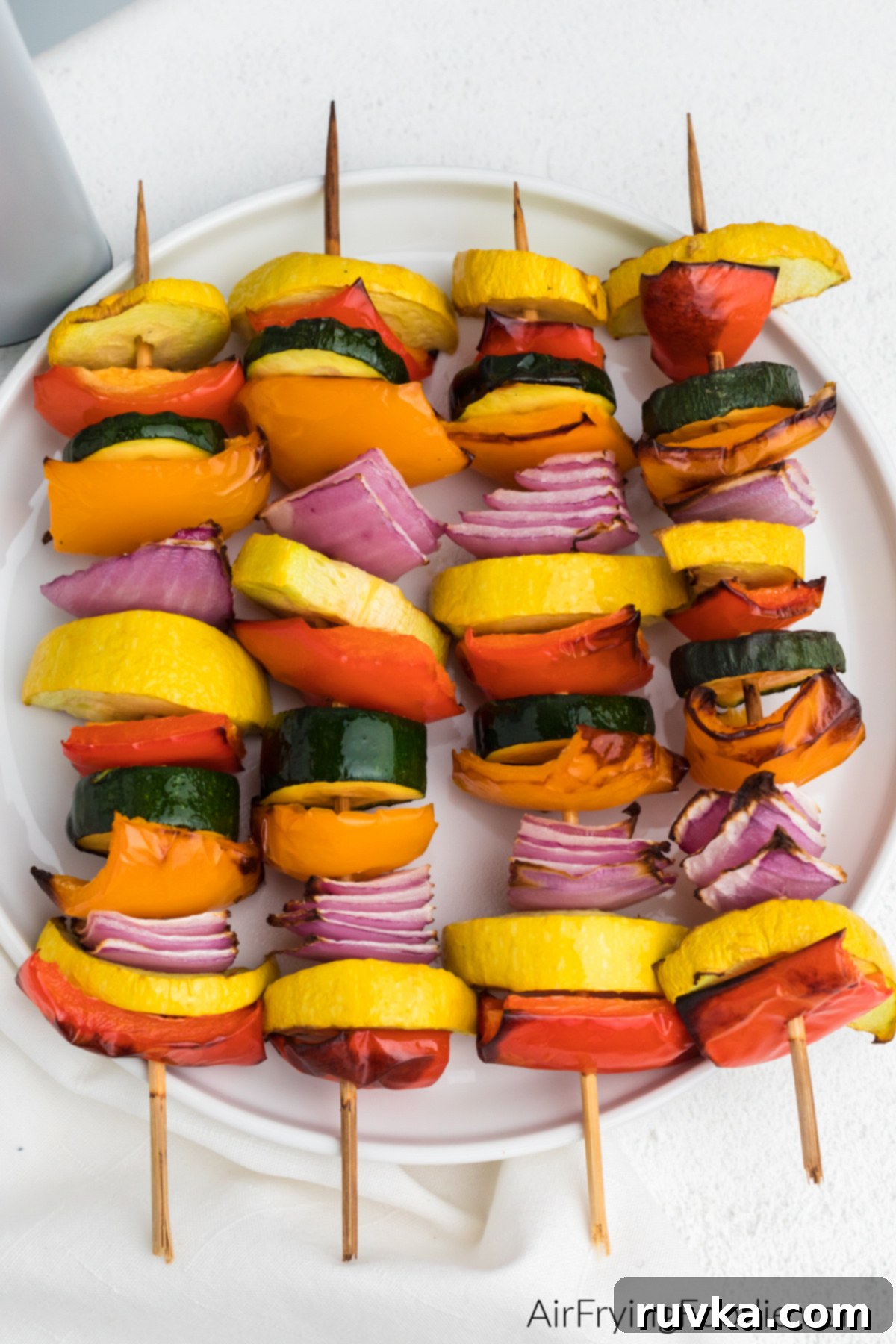 Crispy Air Fryer Vegetable Skewers 7 Beautifully air fried vegetable kabobs arranged artfully on a white plate, ready to be enjoyed.