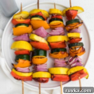 Crispy Air Fryer Vegetable Skewers 9 Vegetable kabobs made in the air fryer and served on a white plate.