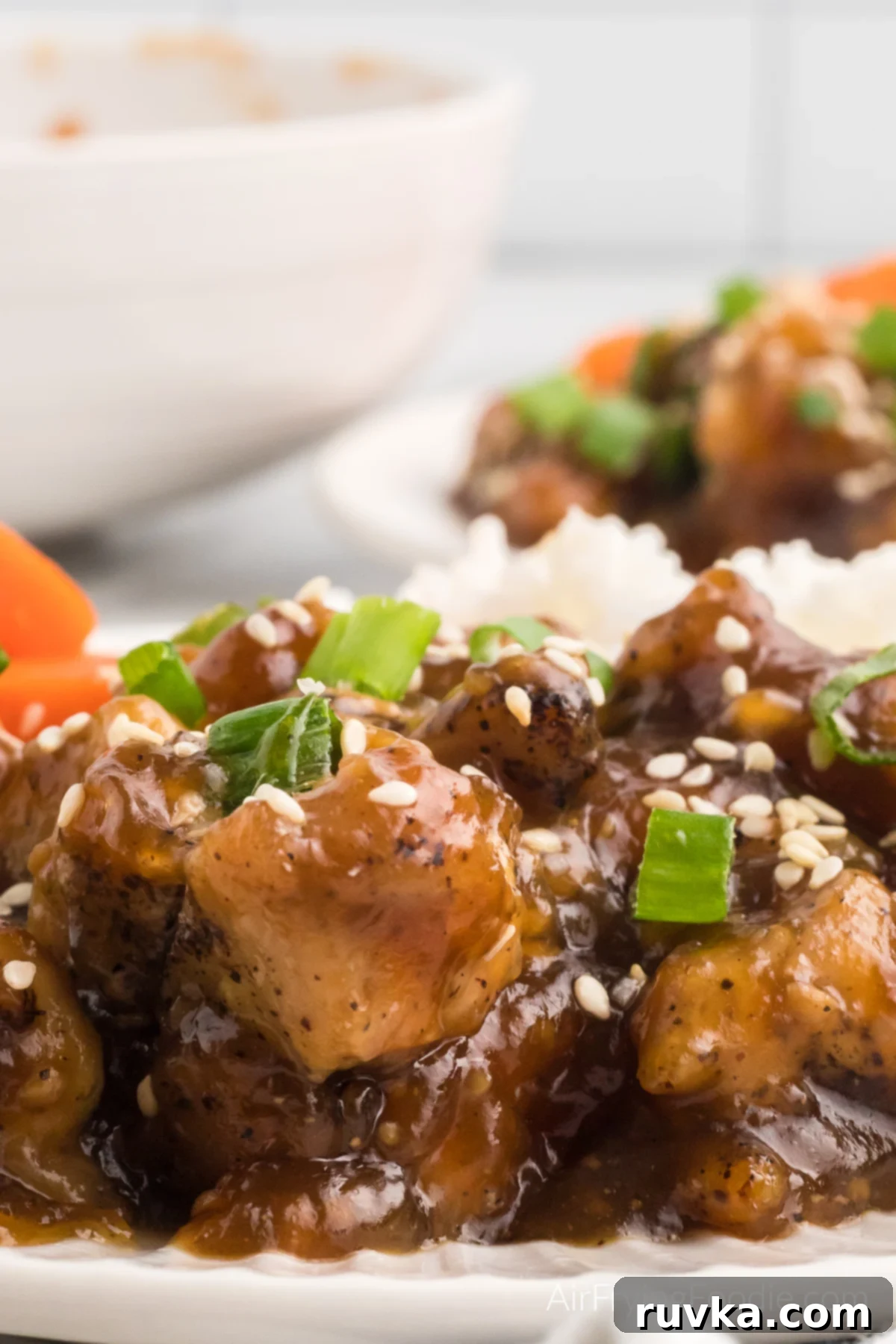 Sticky Sweet Air Fryer Teriyaki Chicken 2 Air fryer teriyaki chicken on a white plate, ready to eat.