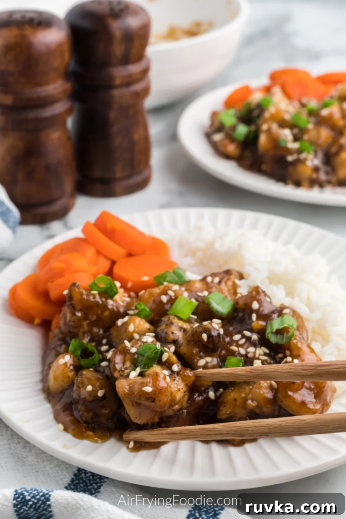 Sticky Sweet Air Fryer Teriyaki Chicken 10 Air Fryer Teriyaki chicken on a plate served with rice and sliced carrots.