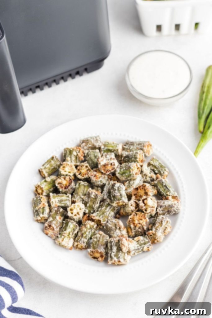 Crispy Air Fryer Okra 8 Golden fried seasoned okra pieces in a white plate.