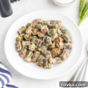 Crispy Air Fryer Okra 10 Golden fried seasoned okra pieces in a white plate.