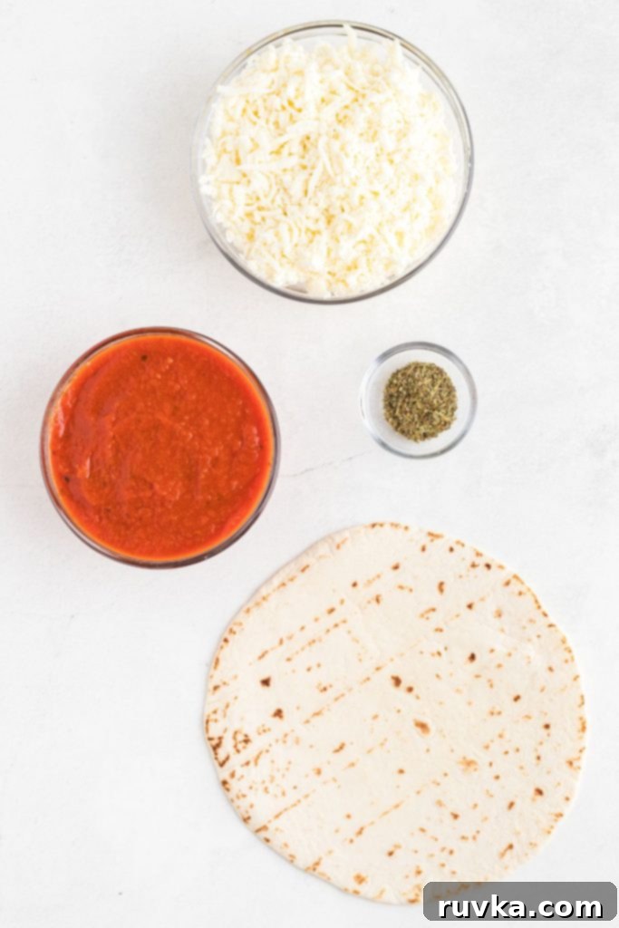 Crispy Air Fryer Tortilla Pizzas 3 Shredded cheese, sauce, seasonings, and tortillas, on a white marble table.