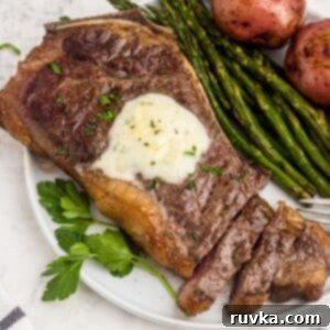 Air Fryer Favorites for Memorial Day 11 Juicy garlic on a white plate with asparagus and potatoes, the steak is sliced with a fork