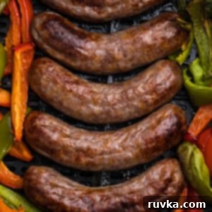 Air Fryer Favorites for Memorial Day 8 Brats and peppers in the basket of the air fryer.