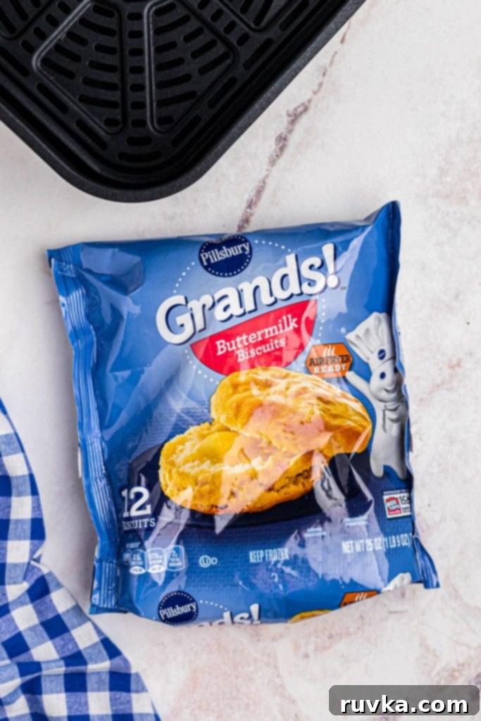 Easy Air Fryer Frozen Biscuits 3 Frozen package of biscuits in front of an air fryer basket.