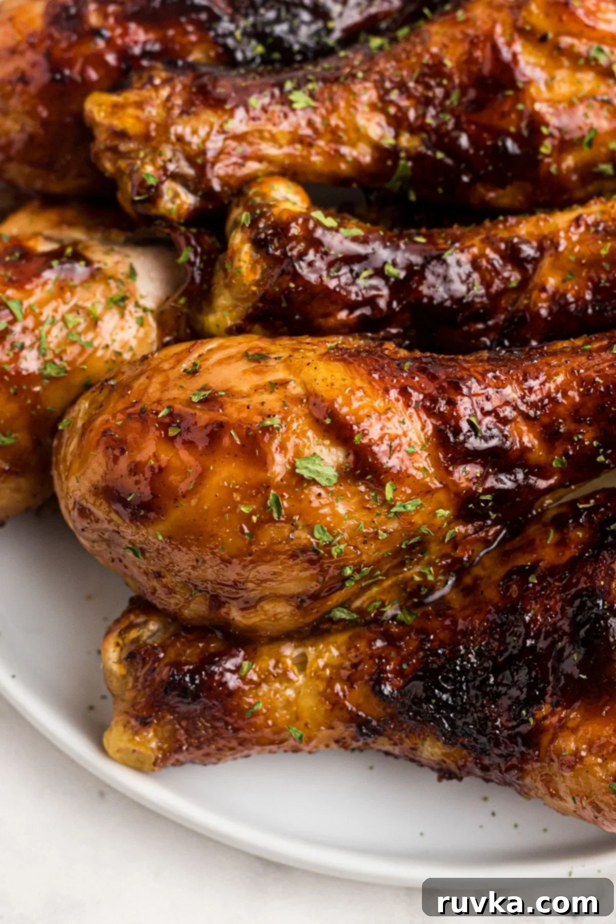 Delicious Air Fryer Chicken Recipes Made Easy 13 Air fried BBQ chicken, richly sauced and perfectly cooked, served on a white plate with a garnish of fresh herbs.