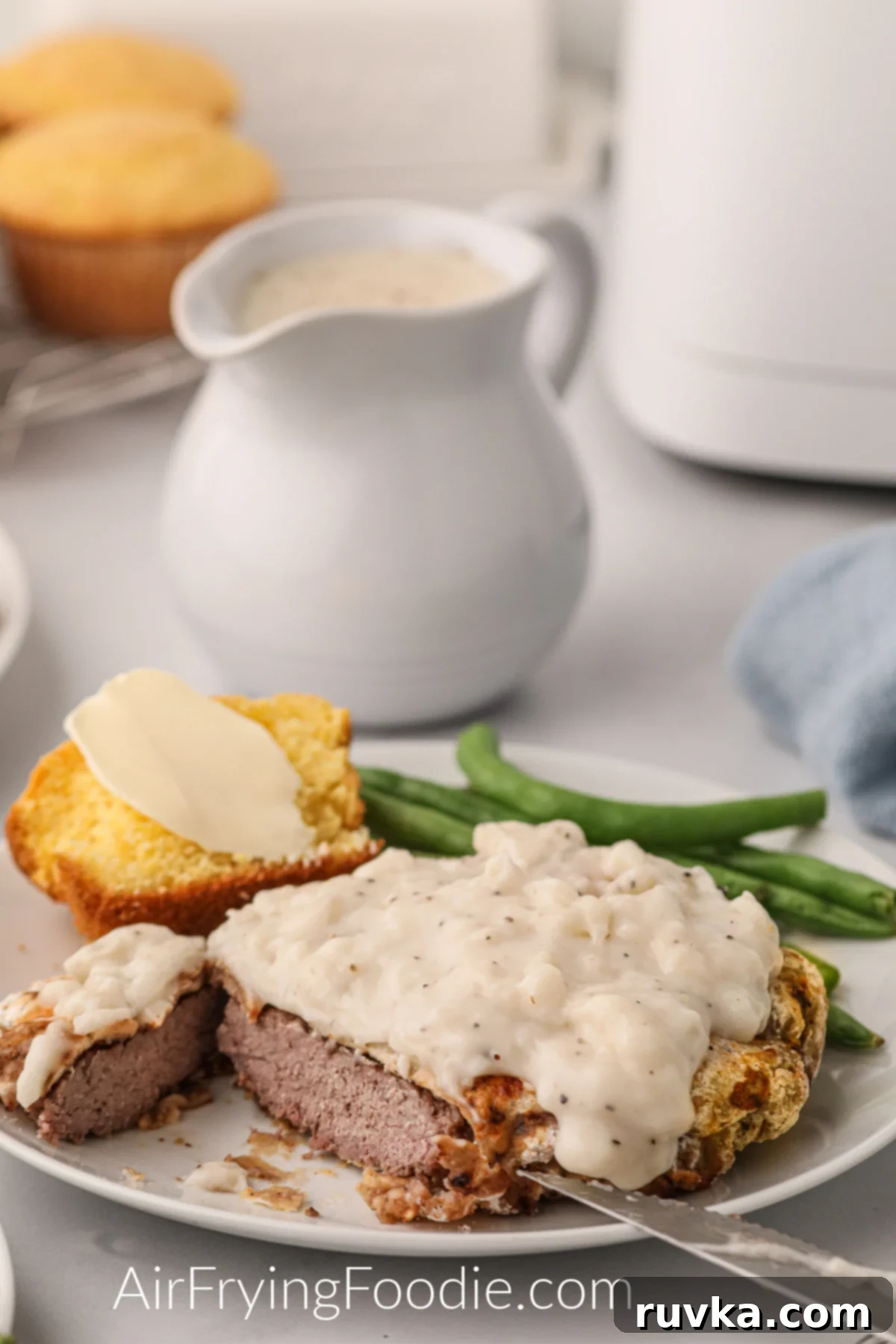 Delicious Air Fryer Chicken Recipes Made Easy 23 Air fryer chicken fried steak, generously covered in creamy gravy and sliced in half, ready to be served.