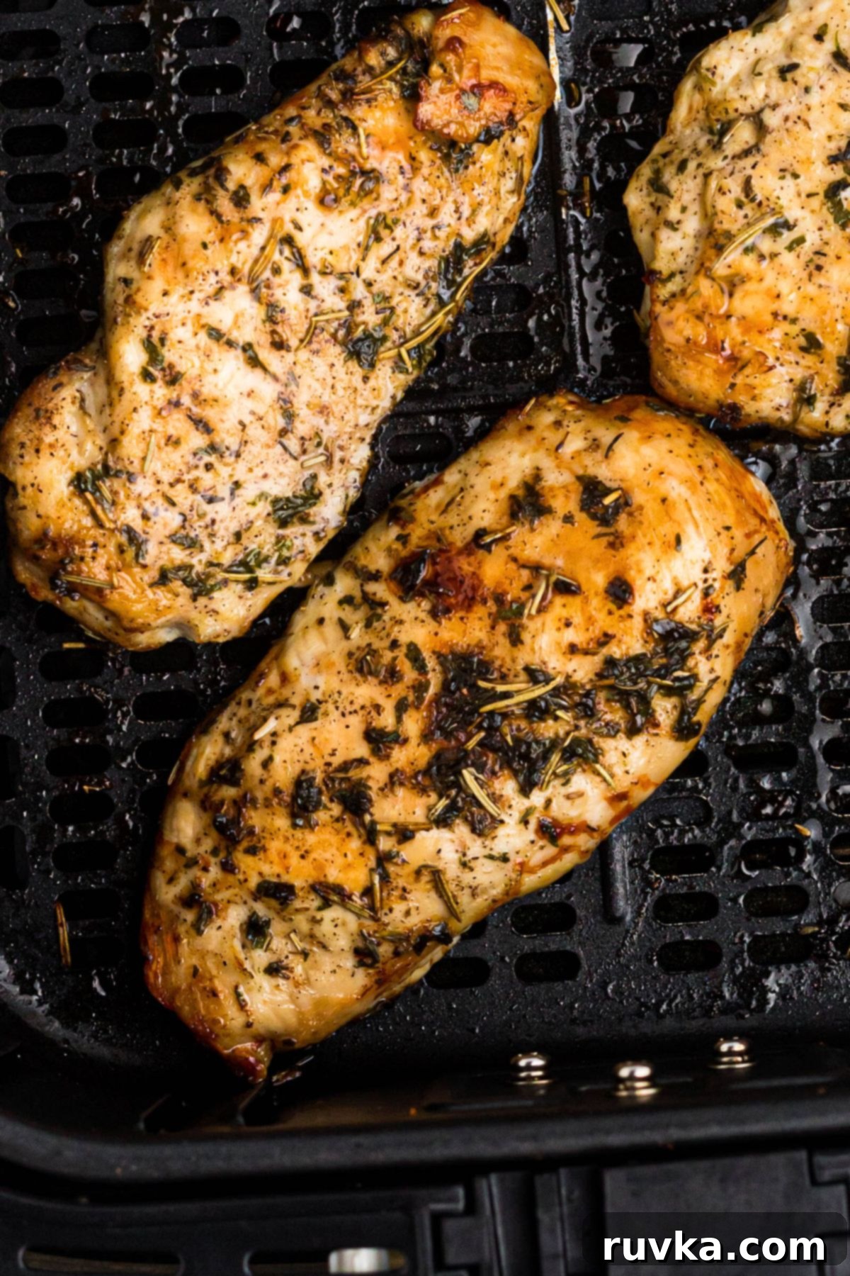 Delicious Air Fryer Chicken Recipes Made Easy 25 Air fryer chicken breast, seasoned and perfectly cooked, resting in the air fryer basket, ready to be served.