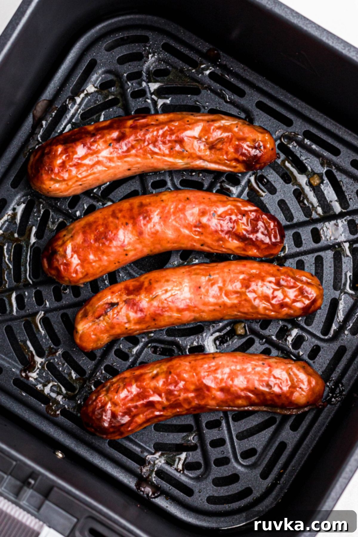 Delicious Air Fryer Chicken Recipes Made Easy 40 Cooked chicken sausage links, golden brown and ready to serve, in the air fryer basket.