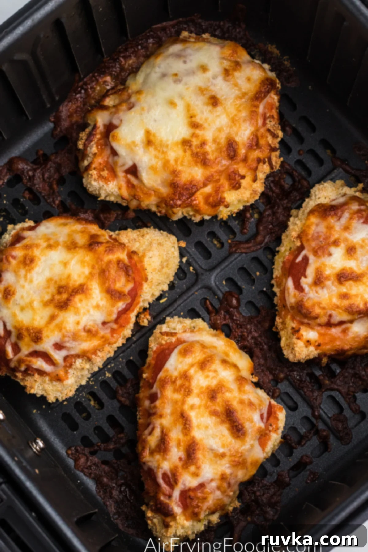 Delicious Air Fryer Chicken Recipes Made Easy 41 Air fryer chicken Parmesan, covered in melted cheese and marinara, in the basket of the air fryer, ready to serve.
