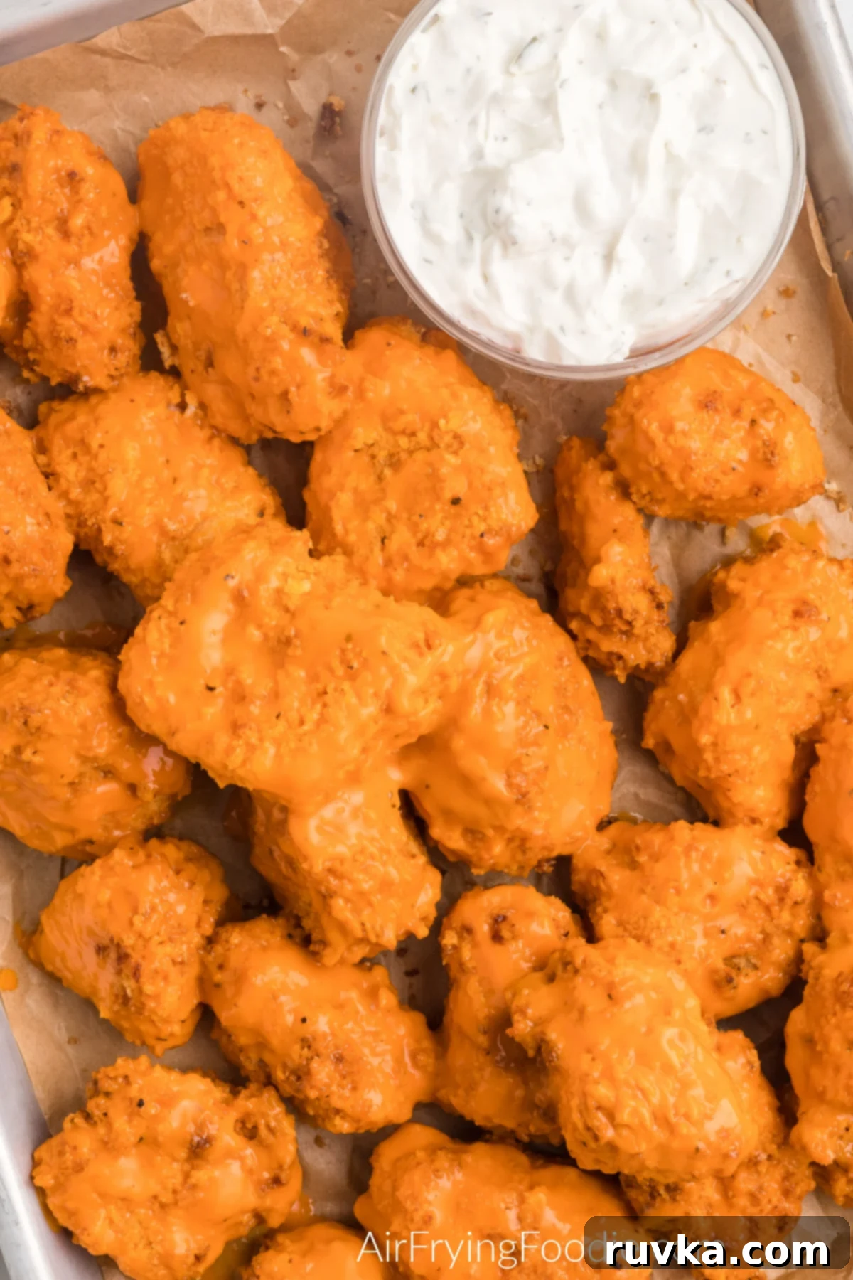 Delicious Air Fryer Chicken Recipes Made Easy 42 Air fryer boneless wings, golden and saucy, arranged on a tray with dipping sauce on the side.