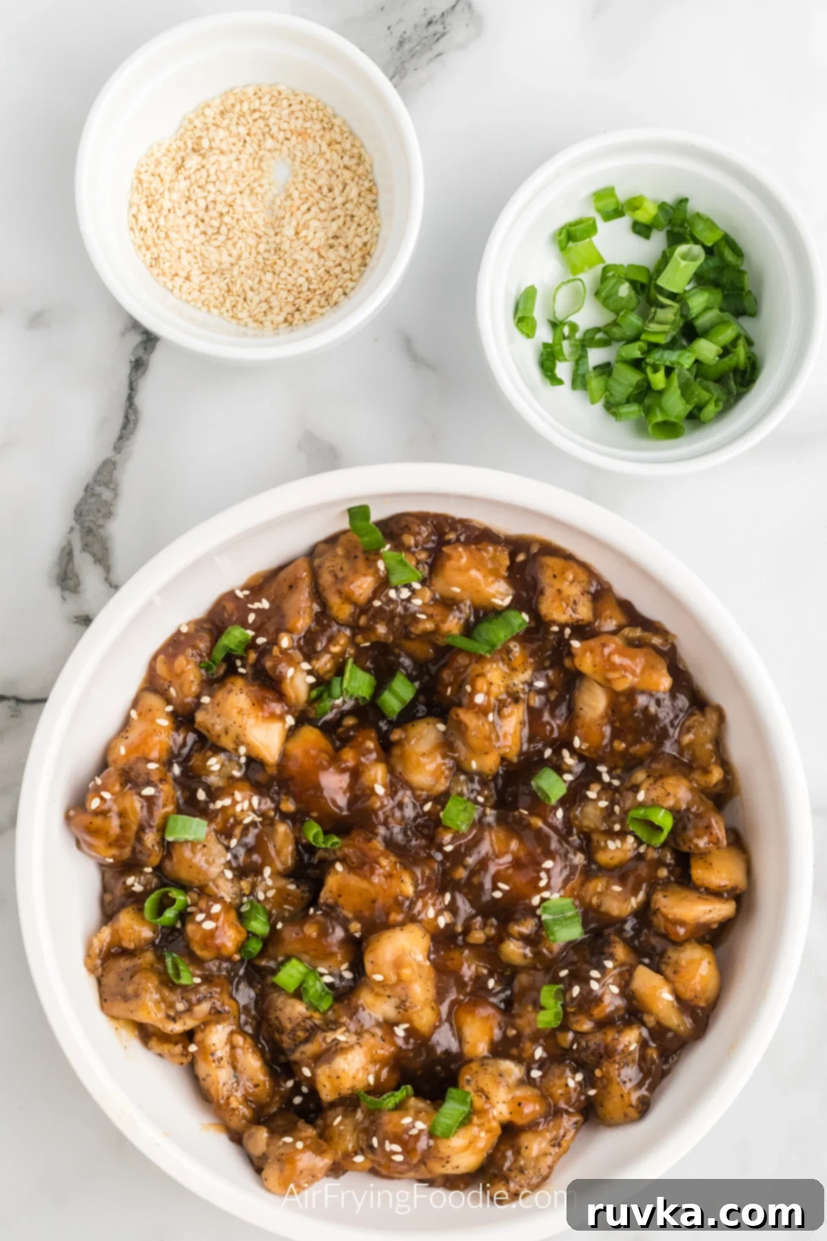 Delicious Air Fryer Chicken Recipes Made Easy 51 Air fryer teriyaki chicken, garnished with sesame seeds and green onion tops, served in a bowl.