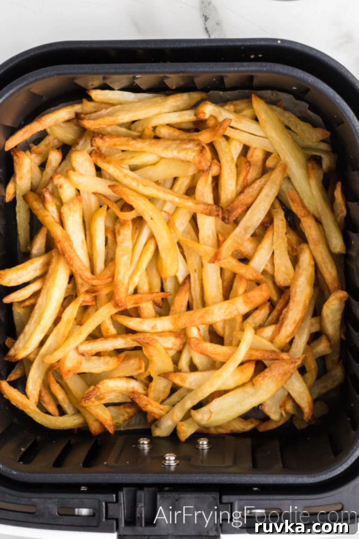 Crispy Leftover Fries in Your Air Fryer 4 Perfectly reheated crispy fries in the basket of the air fryer, ready to be served.