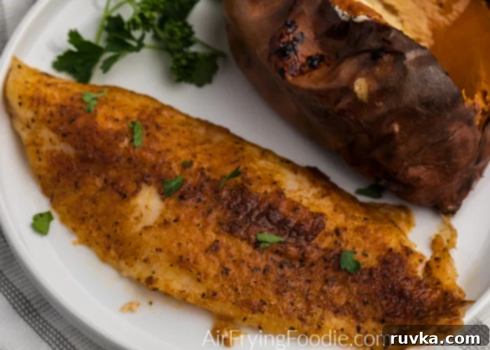 Air Fryer Swai Fish 2 Blackened Swai fish made in the Air Fryer on a white plate with a sweet potato.