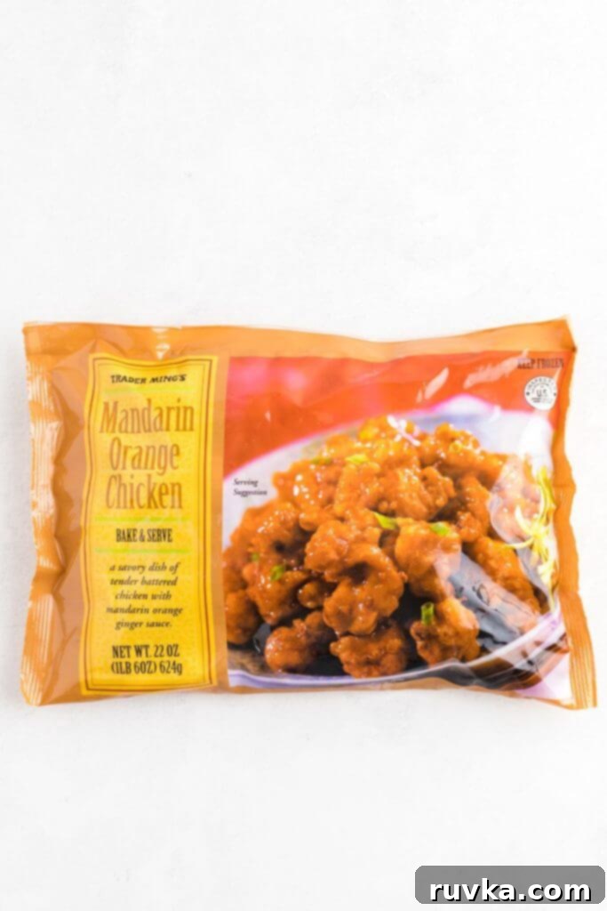 Trader Joes Orange Chicken in the Air Fryer 4 Bag of frozen mandarin orange chicken on a white marble table.