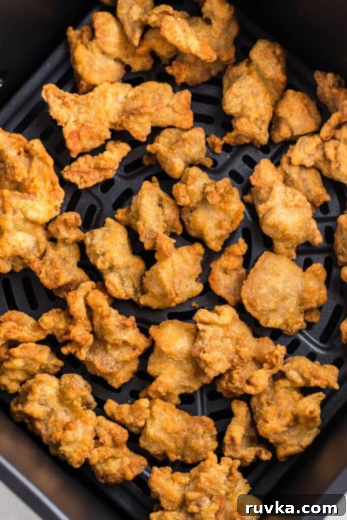 Trader Joes Orange Chicken in the Air Fryer 7 Crispy orange breaded chicken in the air fryer basket after being cooked.