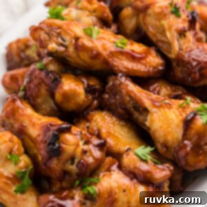 Easy Air Fryer Dinners 11 BBQ Chicken Wings stacked on a white serving tray that have been cooked in the Air Fryer.
