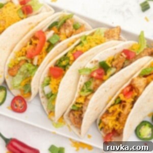 Easy Air Fryer Dinners 13 Seasoned chicken in flour tortillas topped with shredded cheese and chopped tomatoes and peppers.