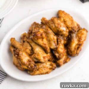 Easy Air Fryer Dinners 6 Air Fryer Honey Garlic Chicken Wings on a white serving dish ready to serve.