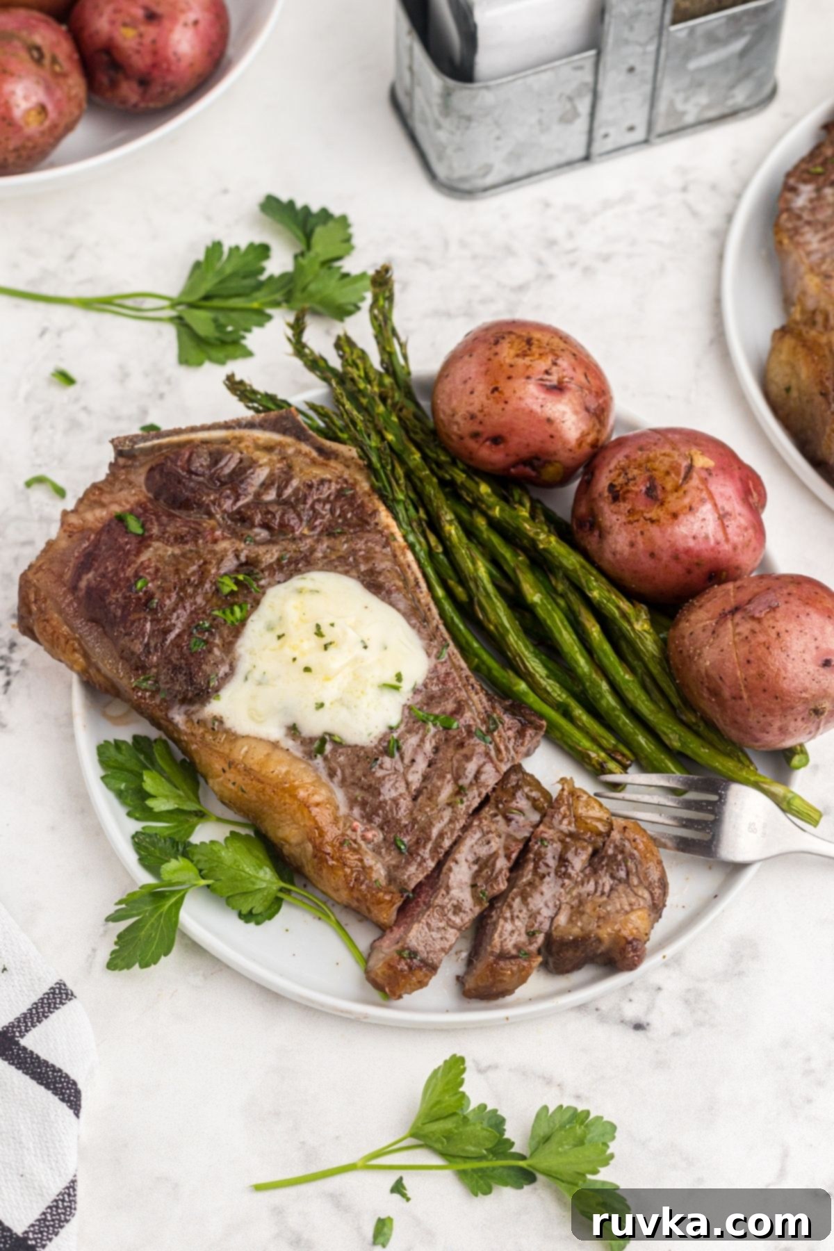 Mastering Air Fryer Leftovers for Crispy Results 8 Cooked steak with asparagus and potatoes on a white plate.