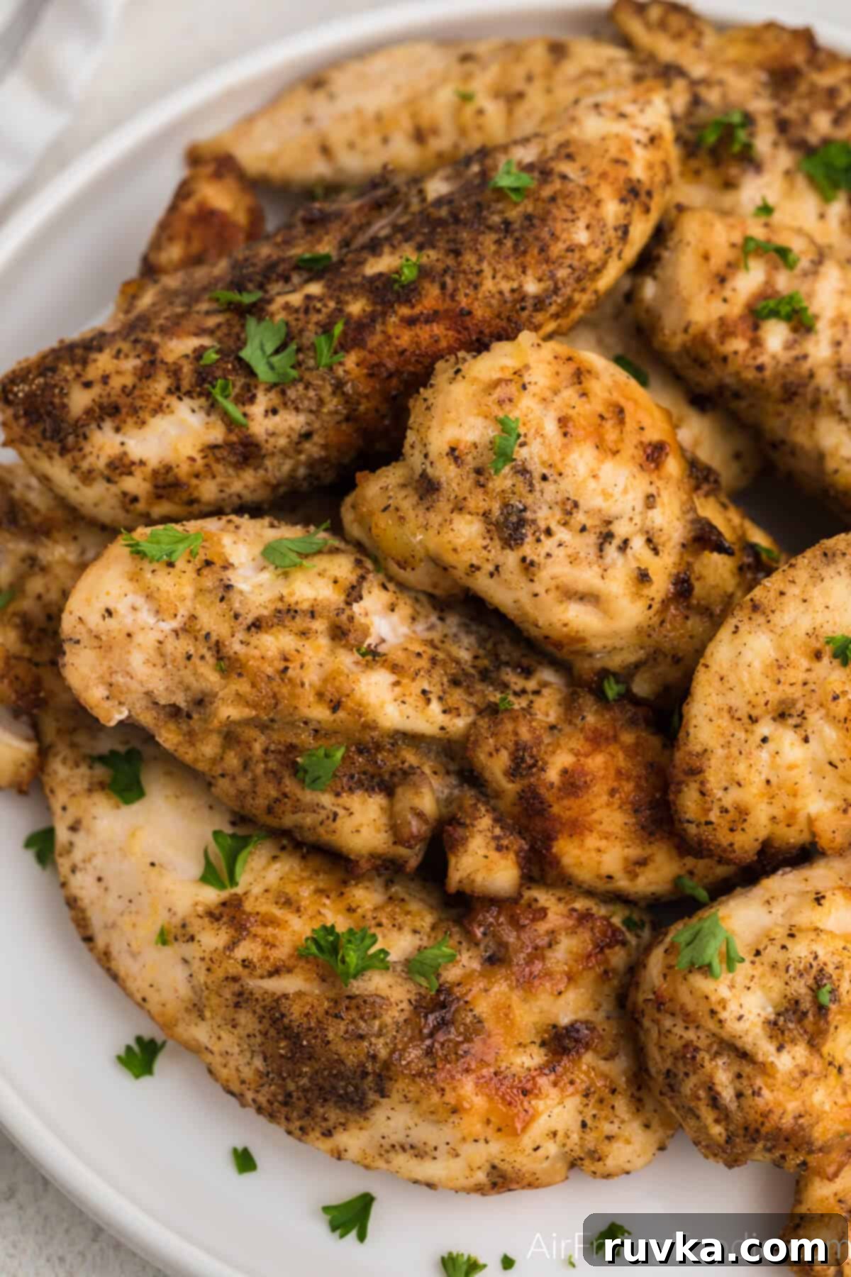 Mastering Air Fryer Leftovers for Crispy Results 10 reheated chicken tenders on a white plate ready to serve.