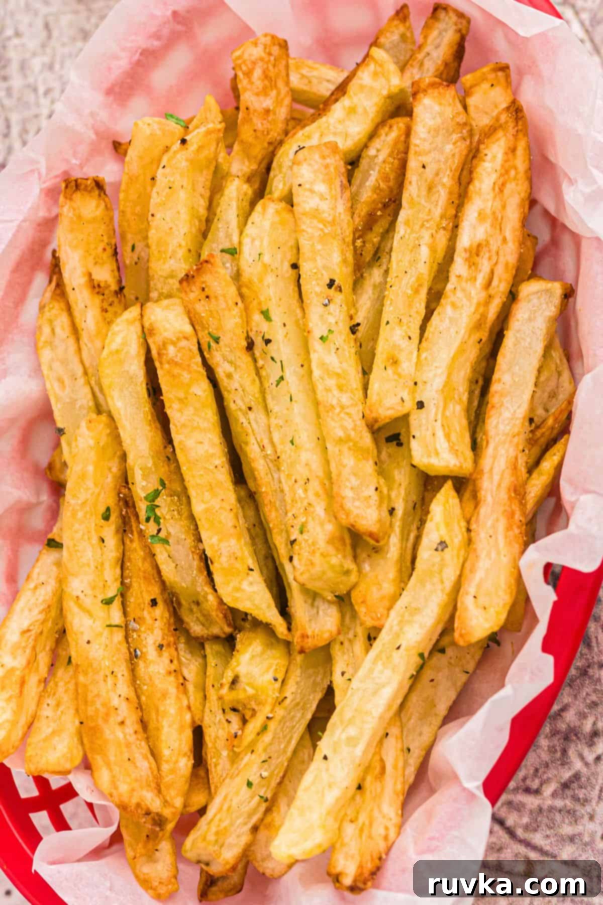 Crispy Air Fryer French Fries 2 Golden French fries seasoned with salt in a red basket.