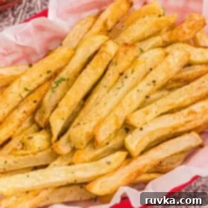 Crispy Air Fryer French Fries 7 Golden seasoned fries in a red basket after being cooked in the air fryer.