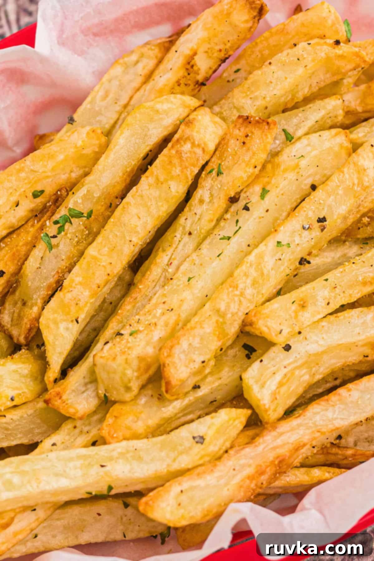 Crispy Air Fryer French Fries 3 Up close photo of French fries seasoned with salt and garnished with small parsley flakes.