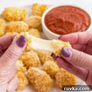 Crispy Air Fryer Cheese Curds 10 Cheese being pulled apart after being melted in the air fryer.