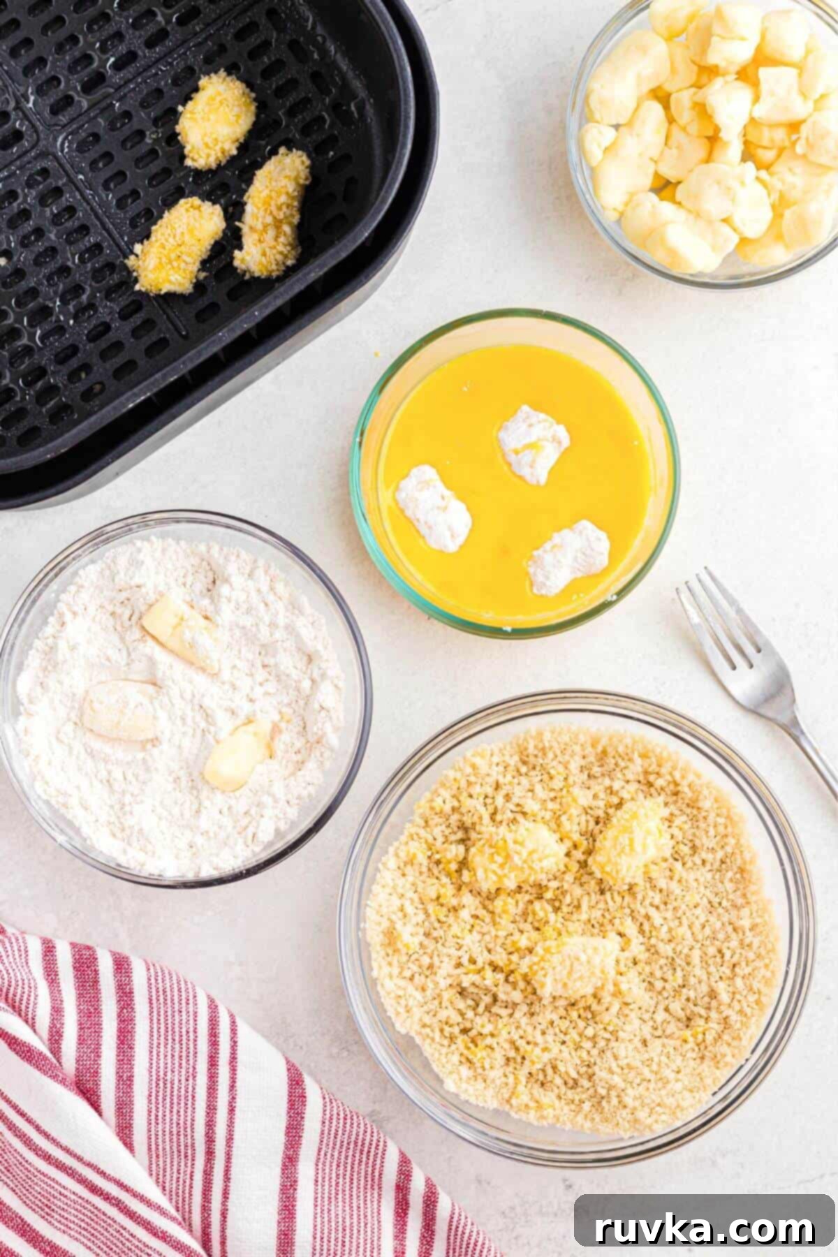 Crispy Air Fryer Cheese Curds 5 Cheese curds being dipped into three different stages of coatings and then put in the air fryer.