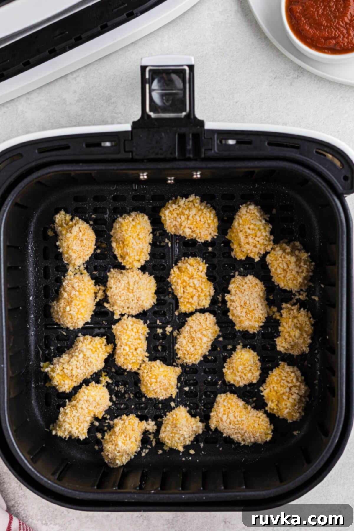 Crispy Air Fryer Cheese Curds 6 Breaded cheese curds in the air fryer basket before being cooked