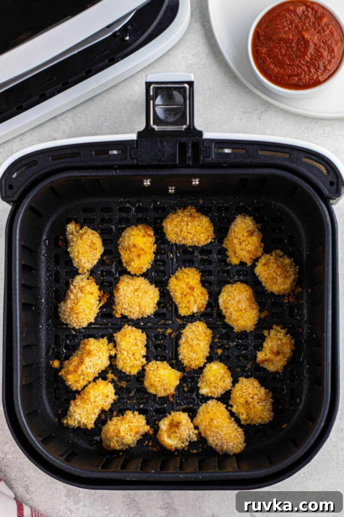 Crispy Air Fryer Cheese Curds 7 Golden fried breaded cheese curds in the air fryer basket.