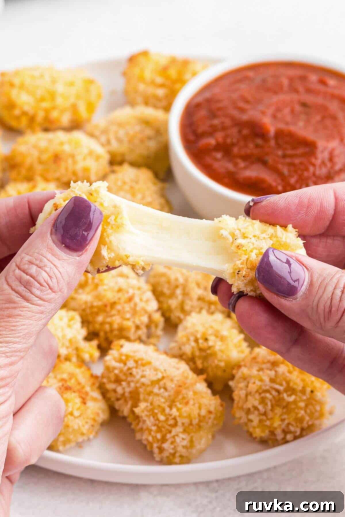 Crispy Air Fryer Cheese Curds 9 Cheese being pulled apart after being melted in the air fryer.