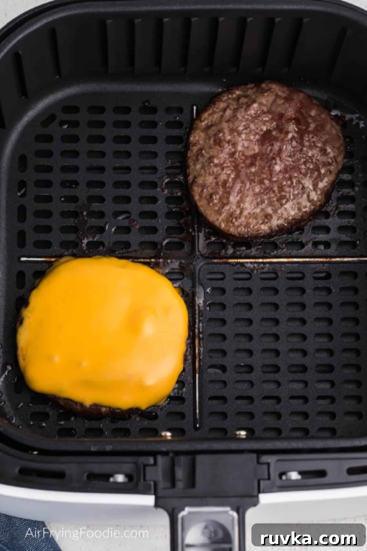 Perfectly Reheat Your Burger in the Air Fryer 3 reheated burgers in the air fryer basket. one with cheese, one plain.