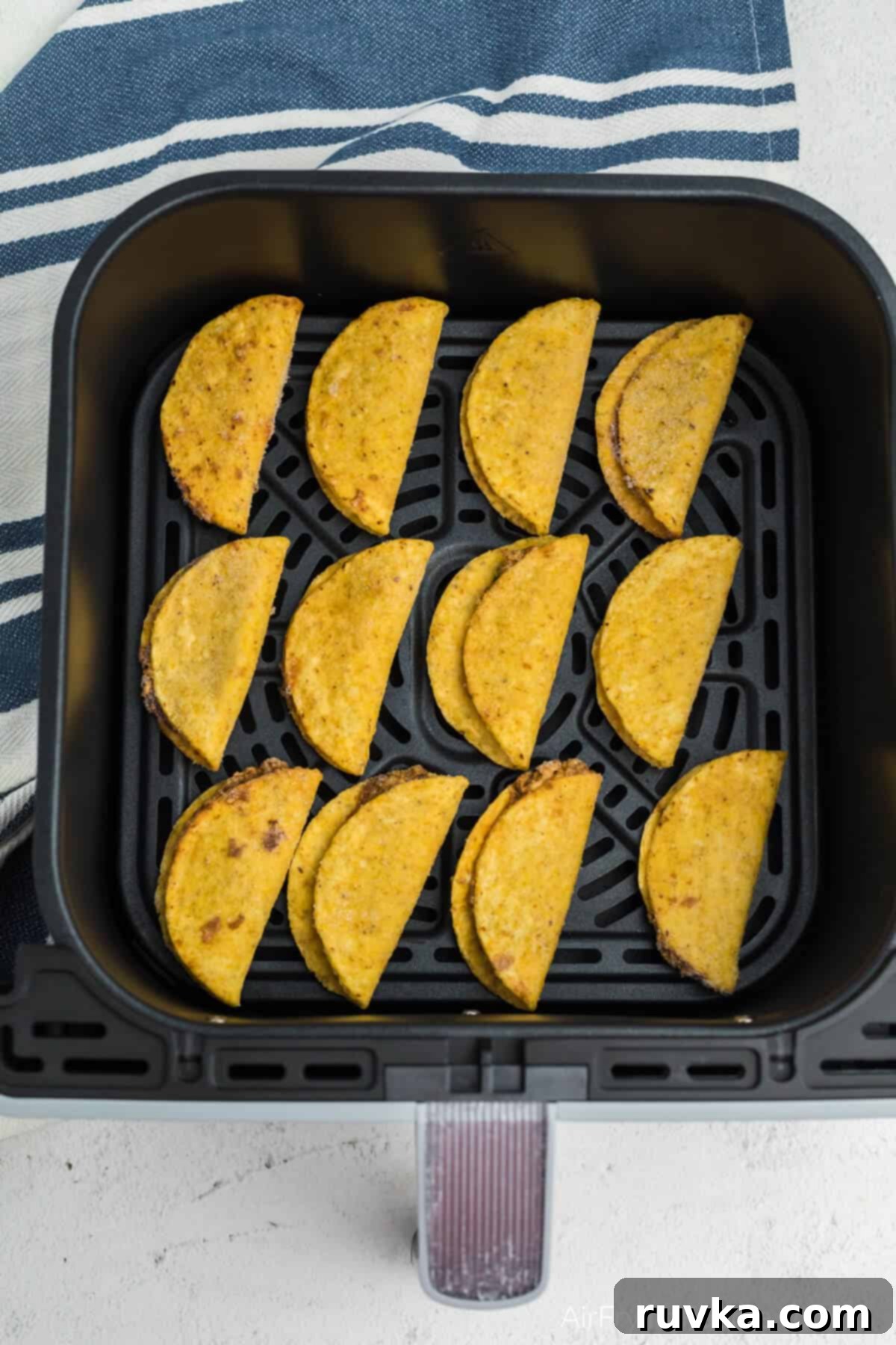 Air Fryer Crispy Taco Bites 4 Frozen mini tacos in air fryer basket, ready to be air fried.