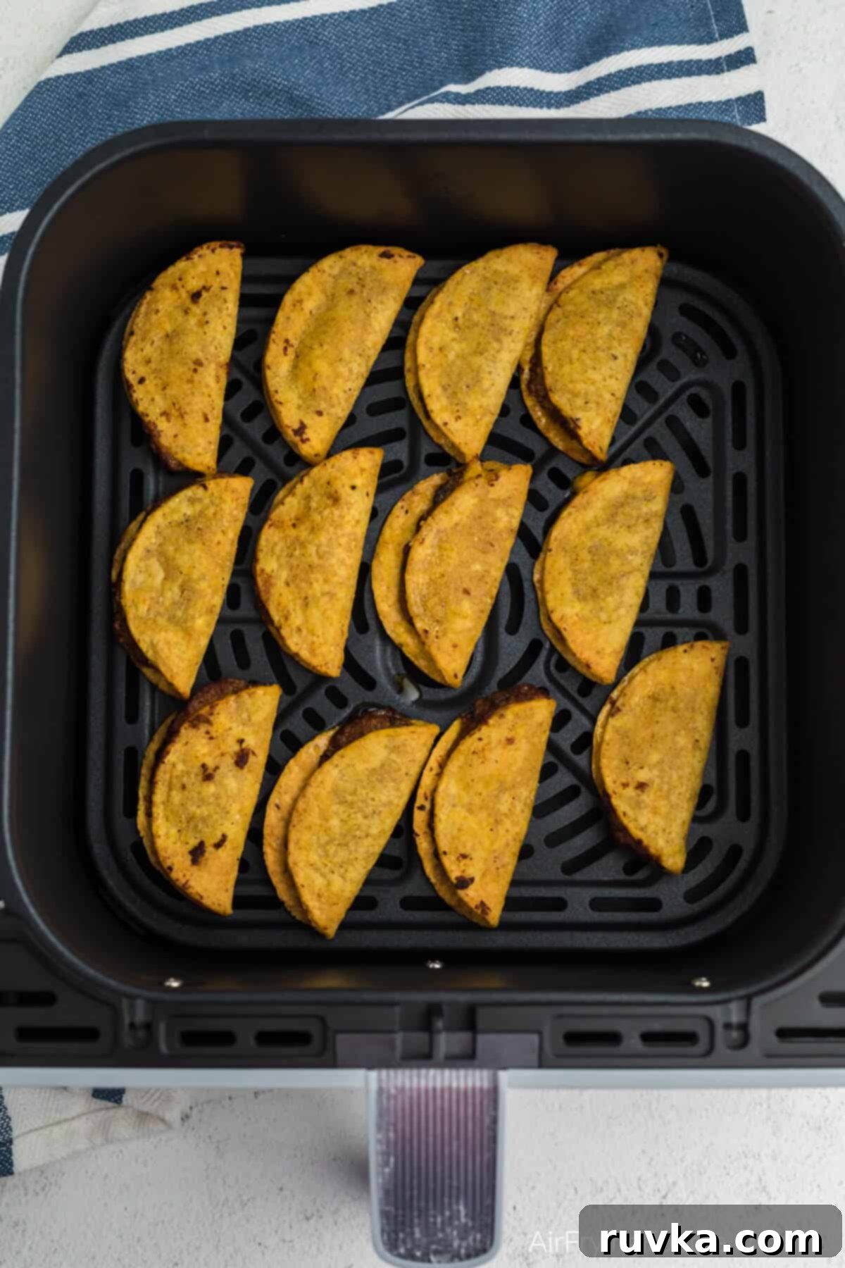 Air Fryer Crispy Taco Bites 5 Frozen mini tacos air fried until fully cooked and golden brown, in basket of the air fryer.
