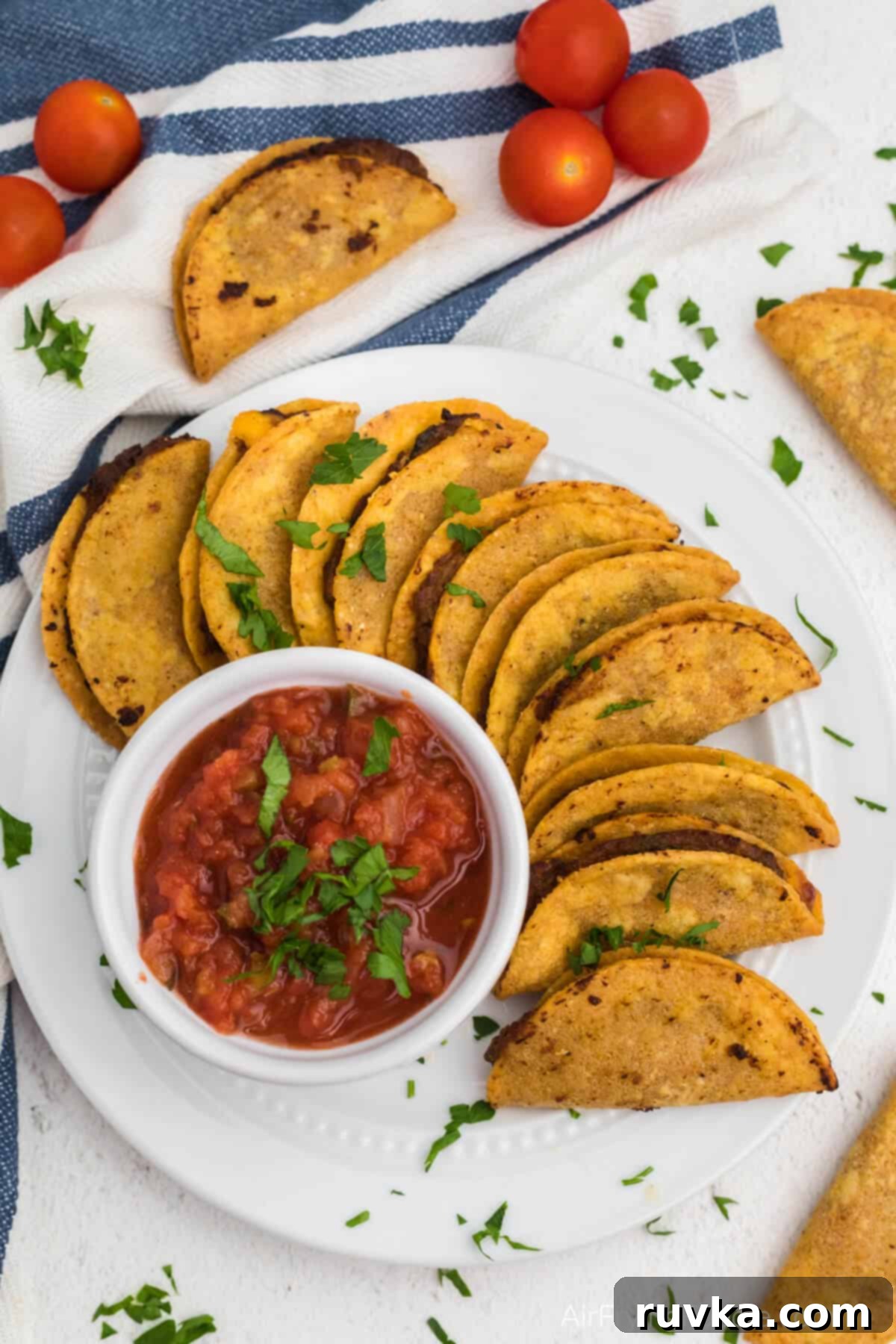 Air Fryer Crispy Taco Bites 6 Overhead photo of mini tacos air fried and served on a white plate with salsa for dipping.