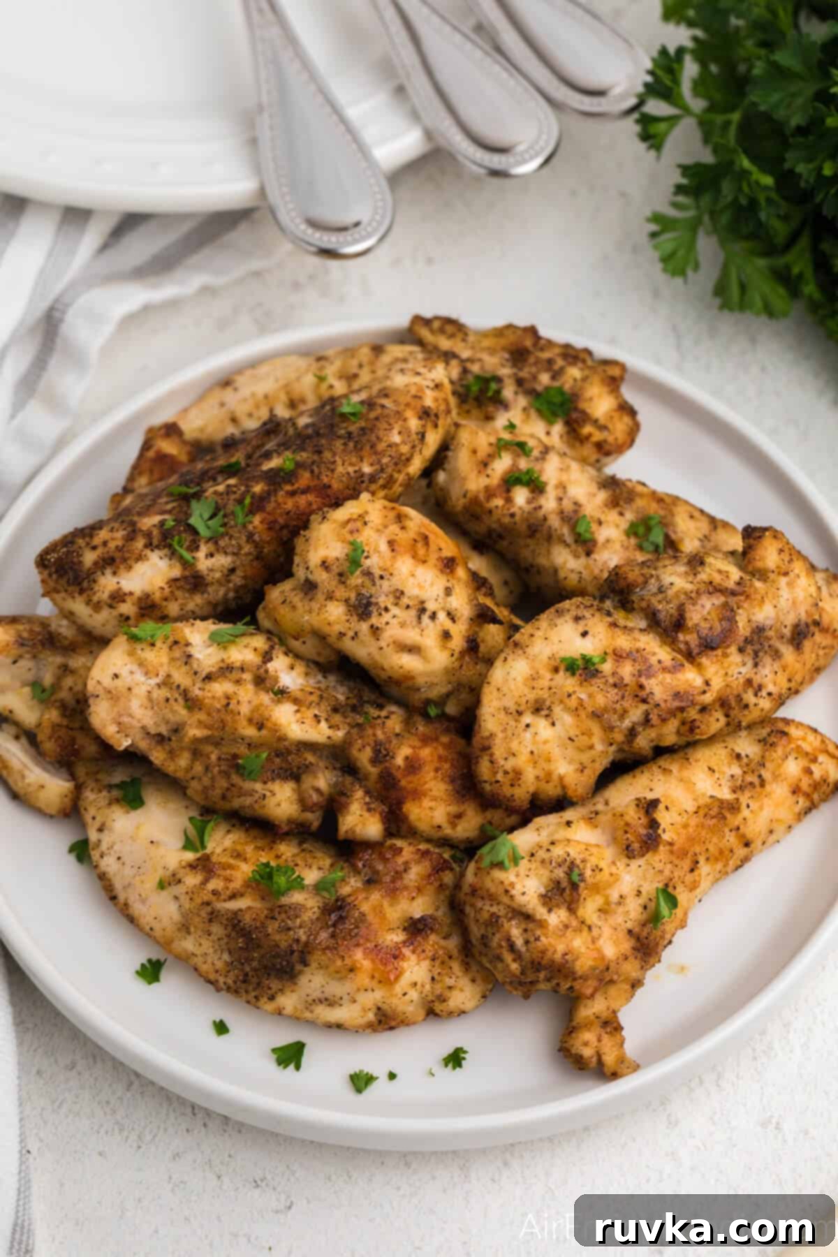 Crispy Air Fryer Chicken Tender Revival 3 Chicken tenders reheated in the air fryer and served on a white plate.