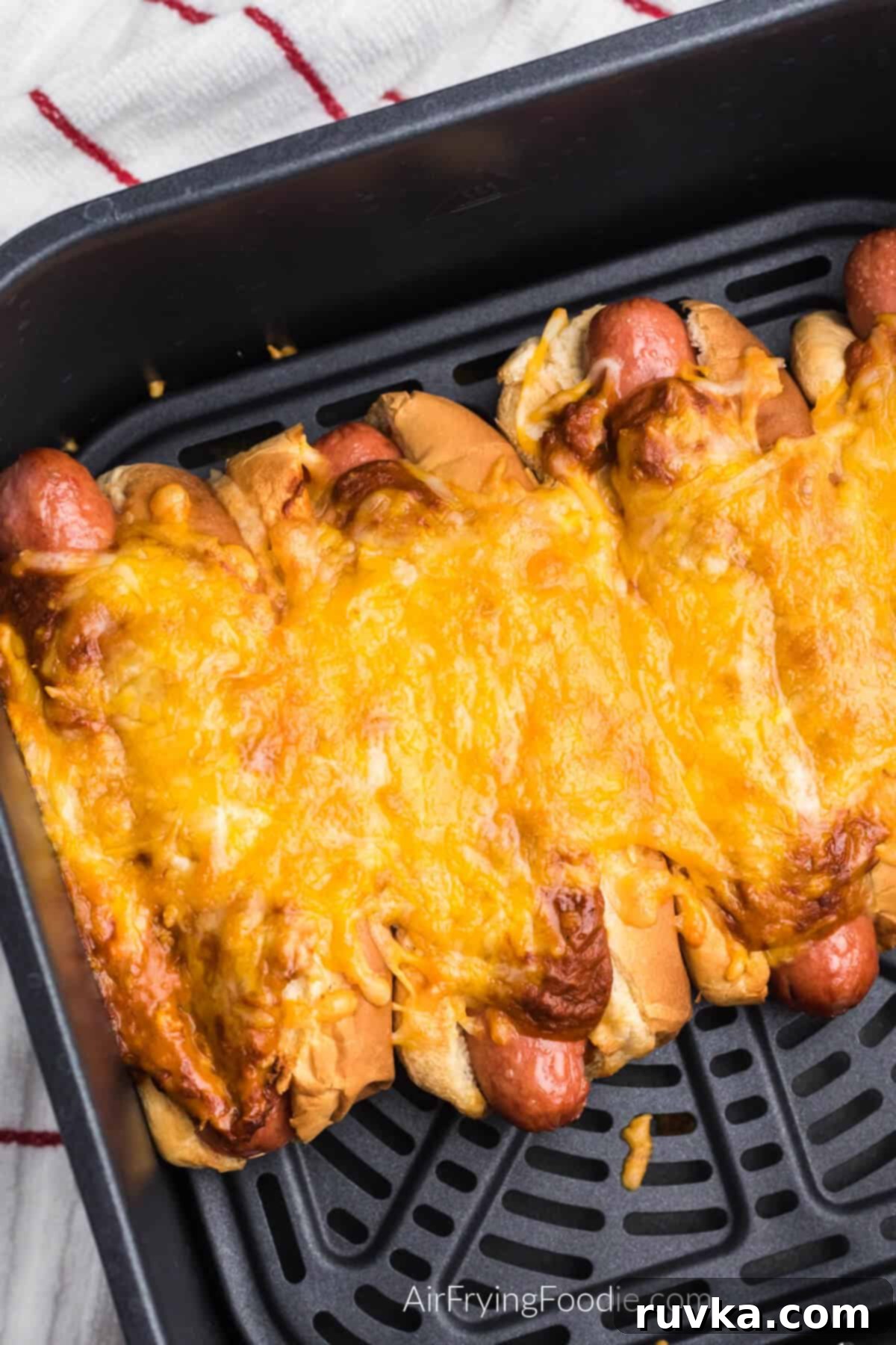 Crispy Air Fryer Chili Cheese Dogs 7 Air fried chili cheese dogs in the basket of the air fryer, perfectly cooked and ready to be served.