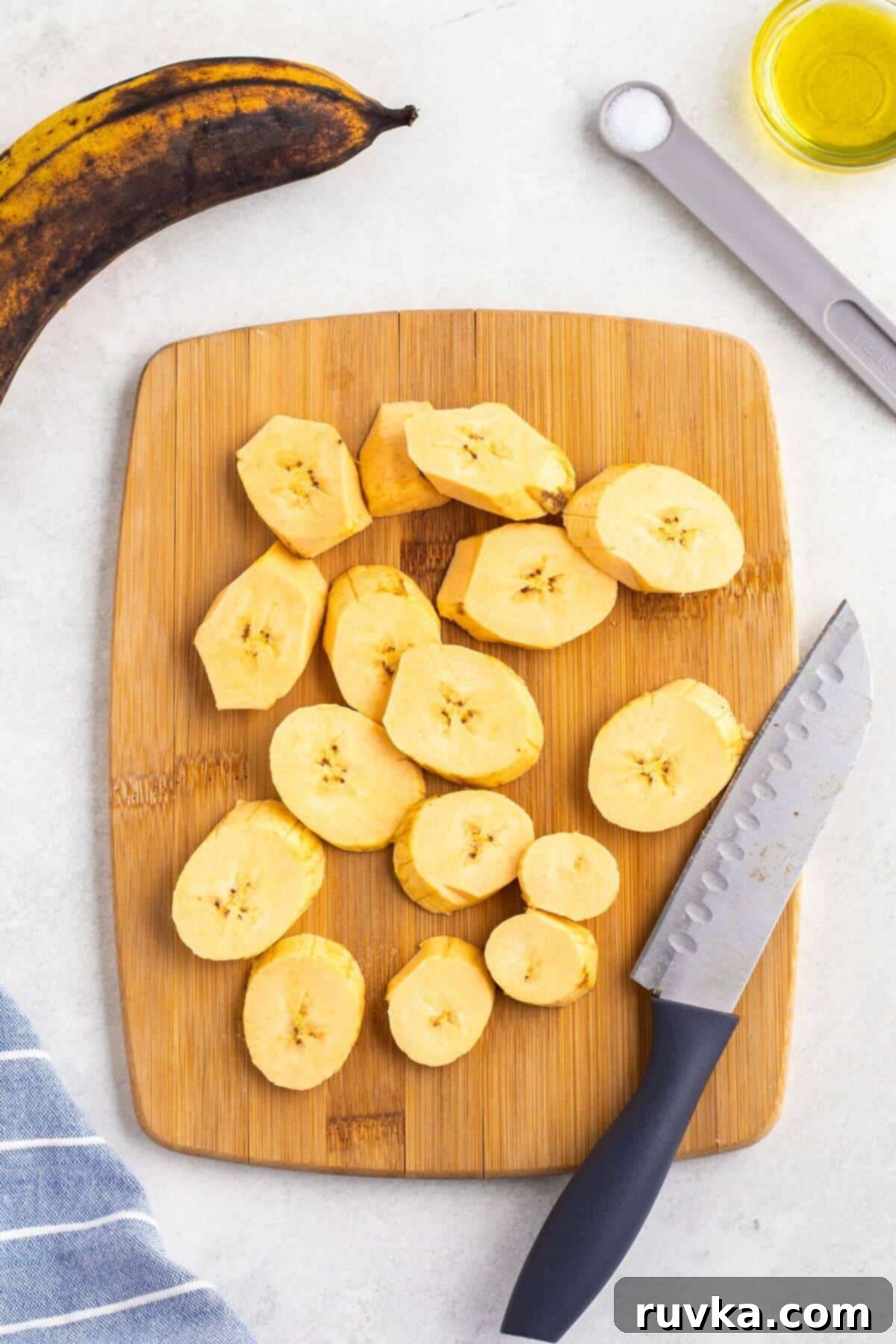 Sweet & Crispy Air Fryer Plantains 4 sliced plantains on a cutting board