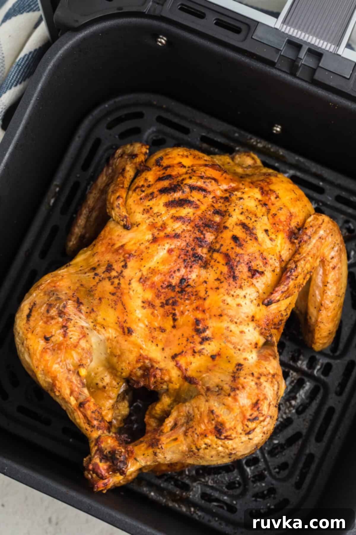 Air Fryer Magic: Reheating Rotisserie Chicken to Perfection 4 Reheated Rotisserie chicken, golden and crispy, perfectly presented in the basket of the air fryer, ready to be served.