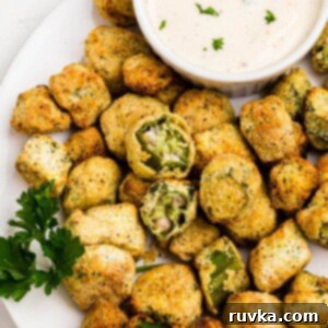 Air Fryer Magic for Frozen Okra 8 Golden breaded okra stacked on a white plate with a small dish or ranch dressing for dipping