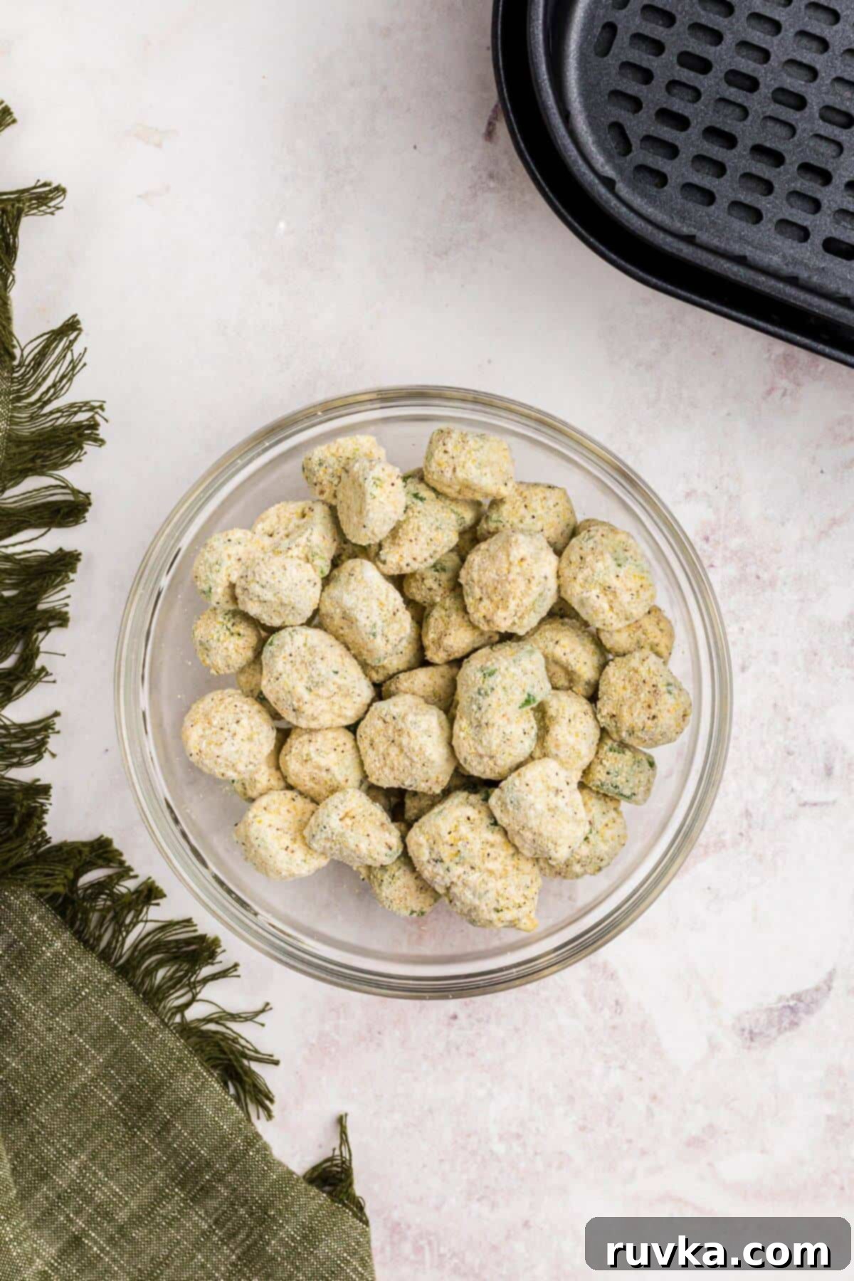 Air Fryer Magic for Frozen Okra 3 Frozen breaded okra in a clear glass bowl before being air fried.