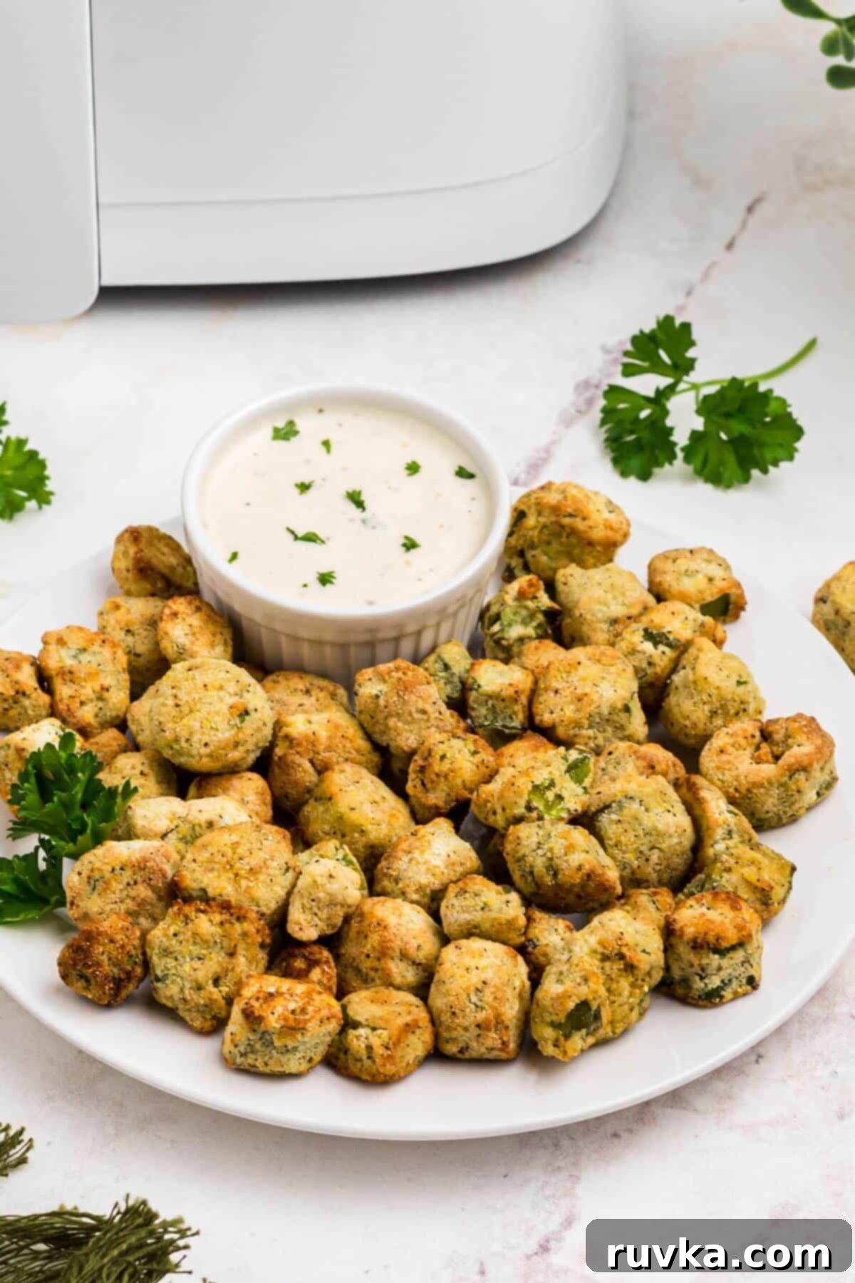 Air Fryer Magic for Frozen Okra 6 Golden breaded fried okra on a white plate in front of an air fryer